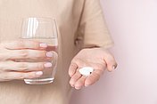 Eine Frau nimmt Antibiotikatabletten, dass kann problematisch sein, weil durch Antibiotikatabletten kann die Darmflora angegriffen werden.
