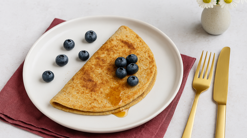 Ein Blaubeer-Bananen-Hafer-Pfannkuchen mit Blaubeeren garniert auf einem Teller angerichtet für eine Low-Fodmap-Ernährung