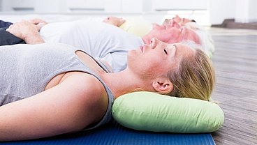 Entspannungstechniken Mehrere Frauen auf dem Boden mit einem Kissen im Nacken und entspannen sich. © drubig-photo - Fotolia