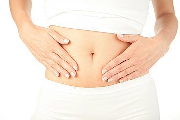 Frau massiert ihren Bauch Eine Frau führt eine Bauchmassage durch zur Entspannung © studiovespa / adobe stock
